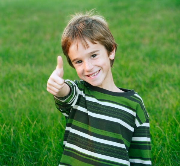 Young dental patient giving thumbs up after children's dentistry visit