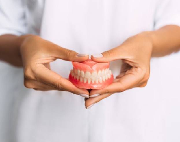 a dentist holding dentures