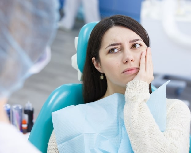 Woman discussing preventing dental emergencies with dentist