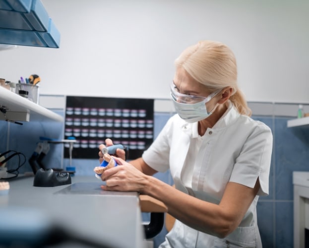 Dental technician crafting dental restoration as part of dental implant process