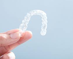 Closeup of patient holding Invisalign aligner