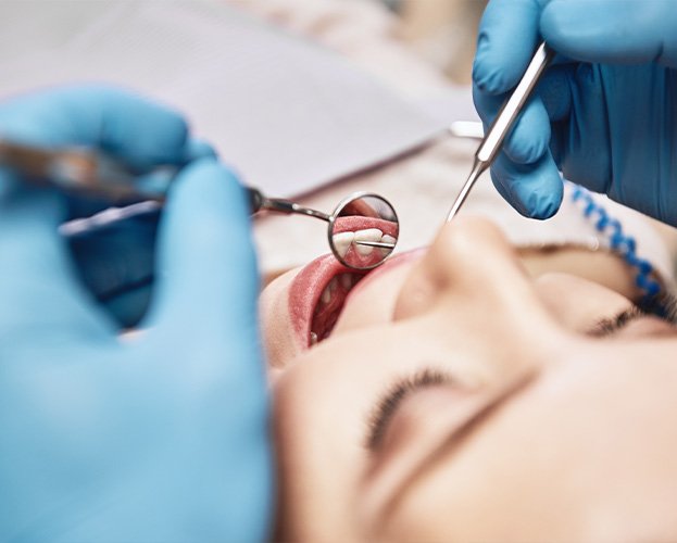 Dentist examining patient during dental checkup and teeth cleaning visit