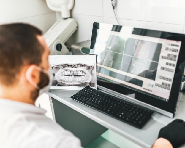 Dentist looking at digital dental x-rays